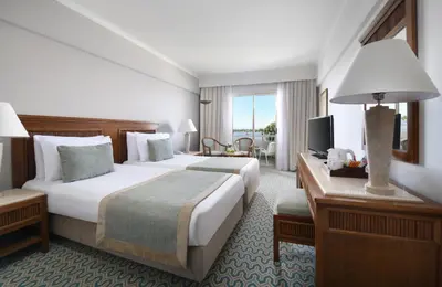 a hotel room with two beds and a desk at Iberotel Luxor in Luxor