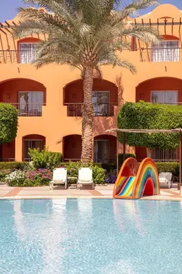 a pool with a rainbow slide in front of a hotel at JAZ Makadi Oasis Resort in Hurghada