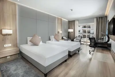 a bedroom with a large white bed and a living room at Steigenberger Nile Palace Luxor - Convention Center in Luxor