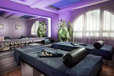 a purple room with two beds and a mirror at Steigenberger Nile Palace Luxor - Convention Center in Luxor