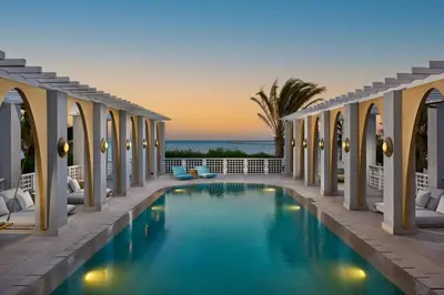 a swimming pool in a resort with the ocean in the background at Sheraton Miramar Resort El Gouna in Hurghada