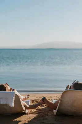 two women laying on towels on the beach at Sheraton Soma Bay Resort in Hurghada