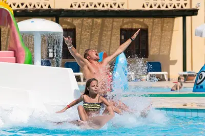 a man and a little girl playing in the water at Three Corners Rihana Resort El Gouna in Hurghada
