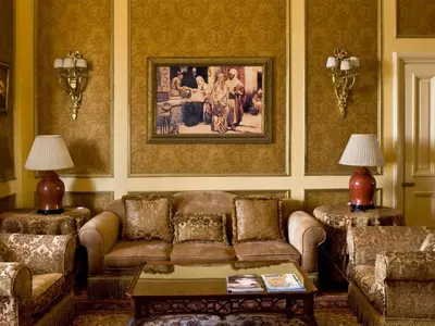 a living room with a couch and a painting on the wall at Sofitel Winter Palace Luxor in Luxor