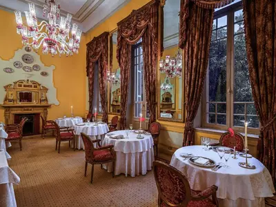 a dining room with tables and chairs and a chandelier at Pavillon Winter Luxor in Luxor