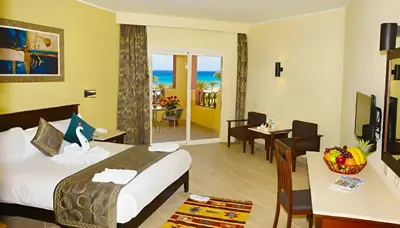 a hotel room with a bed and a dining room at Casa Mare Resort - ex, Royal Tulip Beach Resort in Port Ghalib