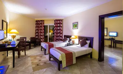 a hotel room with two beds and a desk at Casa Mare Resort - ex, Royal Tulip Beach Resort in Port Ghalib