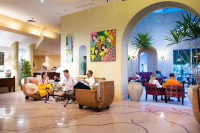 a group of people sitting at a table in a lobby at Three Corners Ocean View El Gouna - Adults Only in Hurghada