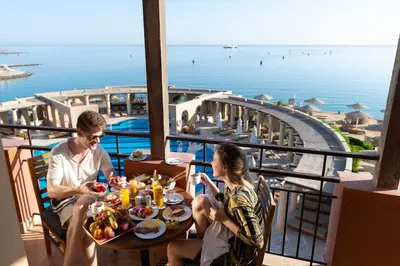 a man and a woman sitting at a table with food at Three Corners Ocean View El Gouna - Adults Only in Hurghada