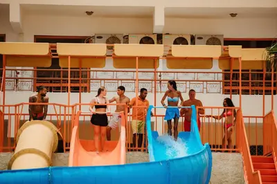 a group of people standing on a water slide at Empire Hotel Aqua Park in Hurghada