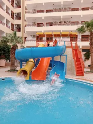 a person in the water on a water slide in a swimming pool at Empire Hotel Aqua Park in Hurghada