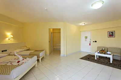 a room with two beds and a living room at Empire Hotel Aqua Park in Hurghada