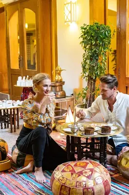 a man and a woman sitting around a table with cupcakes at Three Corners Fayrouz Plaza Beach Resort in Port Ghalib