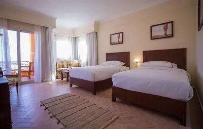 a hotel room with two beds and a balcony at The Cascades Golf Resort, Spa & Thalasso in Hurghada