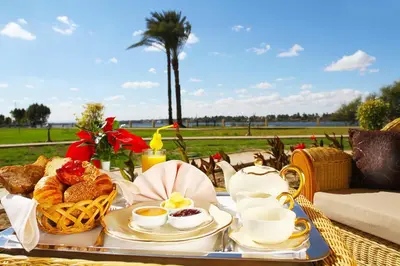 a table with a tray of breakfast food on it at Jolie Ville Hotel & Spa Kings Island Luxor in Luxor