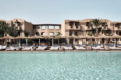 a resort with a swimming pool with chairs and umbrellas at Cook’s Club El Gouna (Adults Only) in Hurghada