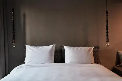 a bed with white sheets and two pillows at Cook’s Club El Gouna (Adults Only) in Hurghada