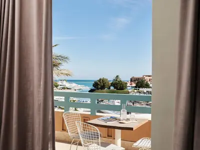 a balcony with a table and chairs and the ocean at Captain's Inn Hotel in Hurghada