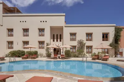 a hotel with a large swimming pool in front of a building at Ali Pasha Hotel in Hurghada