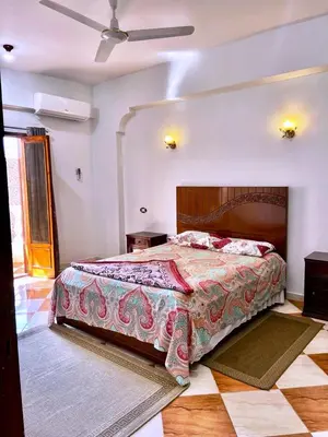 a bedroom with a bed and a ceiling fan at Royal Apartments Luxor in Luxor