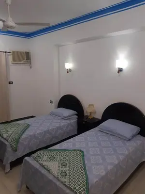 two beds in a room with two beds sidx sidx sidx at Royal Apartments Luxor in Luxor