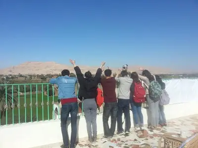 a group of people standing on a bridge with their hands in the air at Royal Apartments Luxor in Luxor