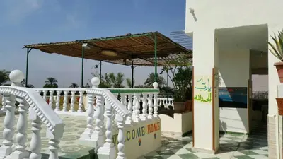 a white fence with an umbrella on a house at Royal Apartments Luxor in Luxor