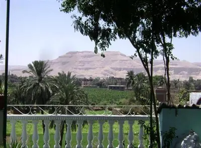 a white fence with a mountain in the background at Royal Apartments Luxor in Luxor