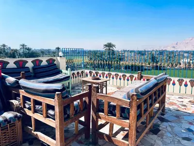 a patio with two benches and a view of the desert at Royal Apartments Luxor in Luxor