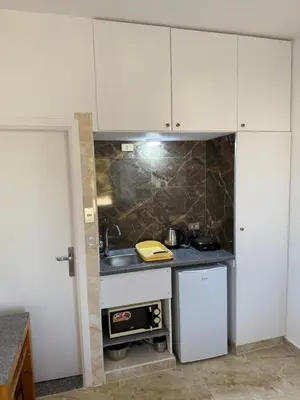 a kitchen with white cabinets and a sink at Mini-Studio With Free Private Beach in Hurghada