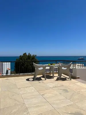 a table and chairs on a balcony overlooking the ocean at Mini-Studio With Free Private Beach in Hurghada