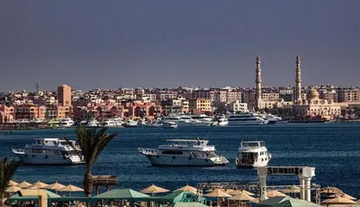 a group of boats in the water near a city at Diamond Arabia Orange in Hurghada