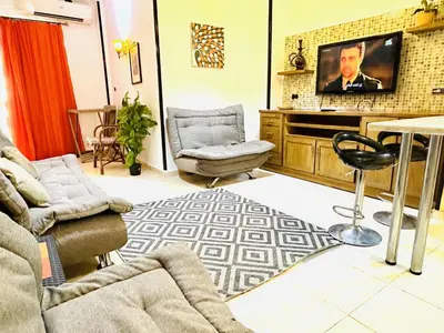 a living room with a couch and a tv at Diamond Arabia Orange in Hurghada