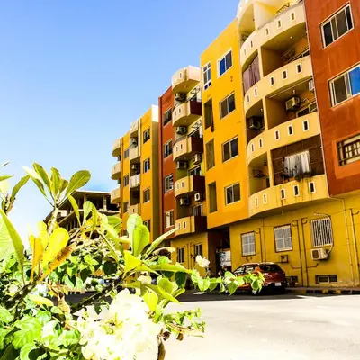 a yellow building with a car parked in front of it at Diamond Arabia Orange in Hurghada
