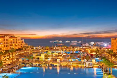 a view of a harbor at night with boats in the water at Pickalbatros White Beach Resort - Hurghada in Hurghada