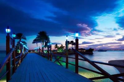 a boardwalk with lights on it next to the water at Hurghada Marriott Beach Resort in Hurghada