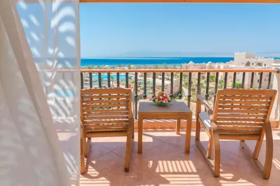 two chairs and a table on a balcony with the beach at Kempinski Hotel Soma Bay in Hurghada