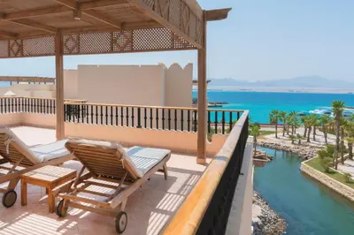 a patio with chairs and a view of the ocean at Kempinski Hotel Soma Bay in Hurghada
