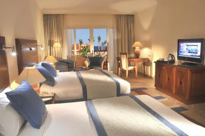 a hotel room with two beds and a television at JAZ Grand Marsa in Coraya Bay