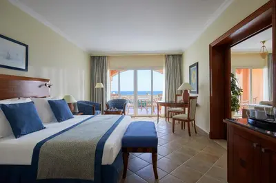 a hotel room with a bed and a balcony at JAZ Grand Marsa in Coraya Bay