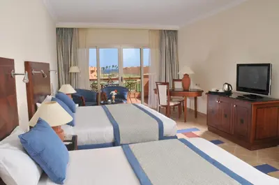 a hotel room with two beds and a television at JAZ Grand Marsa in Coraya Bay