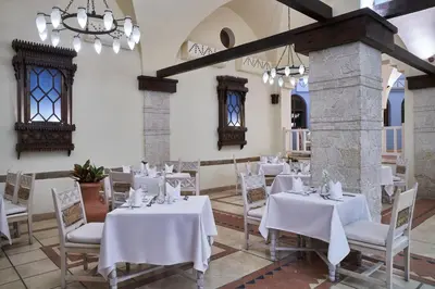 a dining room with white tables and chairs at Hotel Sultan Bey Resort in Hurghada