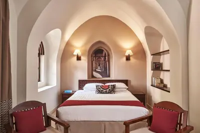a bedroom with a bed and two chairs at Hotel Sultan Bey Resort in Hurghada