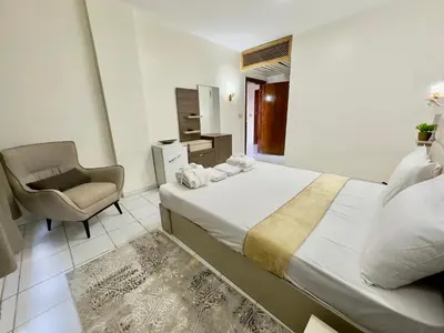 a bedroom with a large bed and a chair at Gaddis Hotel, Suites and Apartments in Luxor