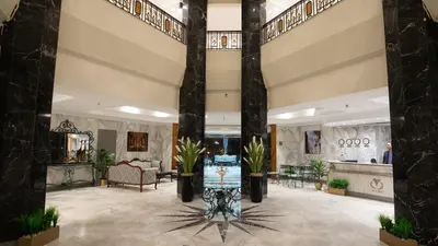 a lobby with palm trees in a building at Lotus Luxor Hotel in Luxor