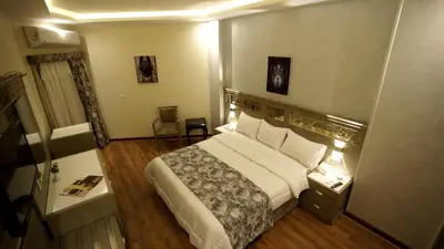 a hotel room with a large bed and a table at Lotus Luxor Hotel in Luxor