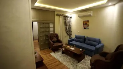 a living room with a blue couch and two chairs at Lotus Luxor Hotel in Luxor