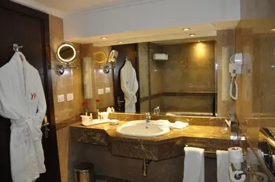 a bathroom with a sink and a large mirror at Aracan Eatabe Luxor Hotel in Luxor