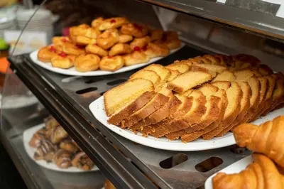 a display case with plates of bread and pastries at Aracan Eatabe Luxor Hotel in Luxor