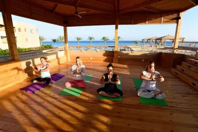 a group of women doing yoga on the beach at The Breakers Diving and Surfing Lodge Soma Bay in Hurghada